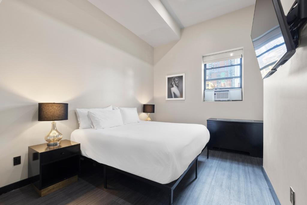 Minimalist bedroom with white bedding and TV